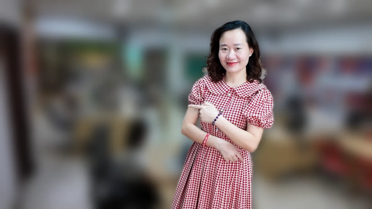 Chị Thảo Nguyễn váy caro khoanh tay, mỉm cười nhìn nghiêng tại văn phòng Tâm - Tầm - Tài – chia sẻ về báo cáo tài chính năm
