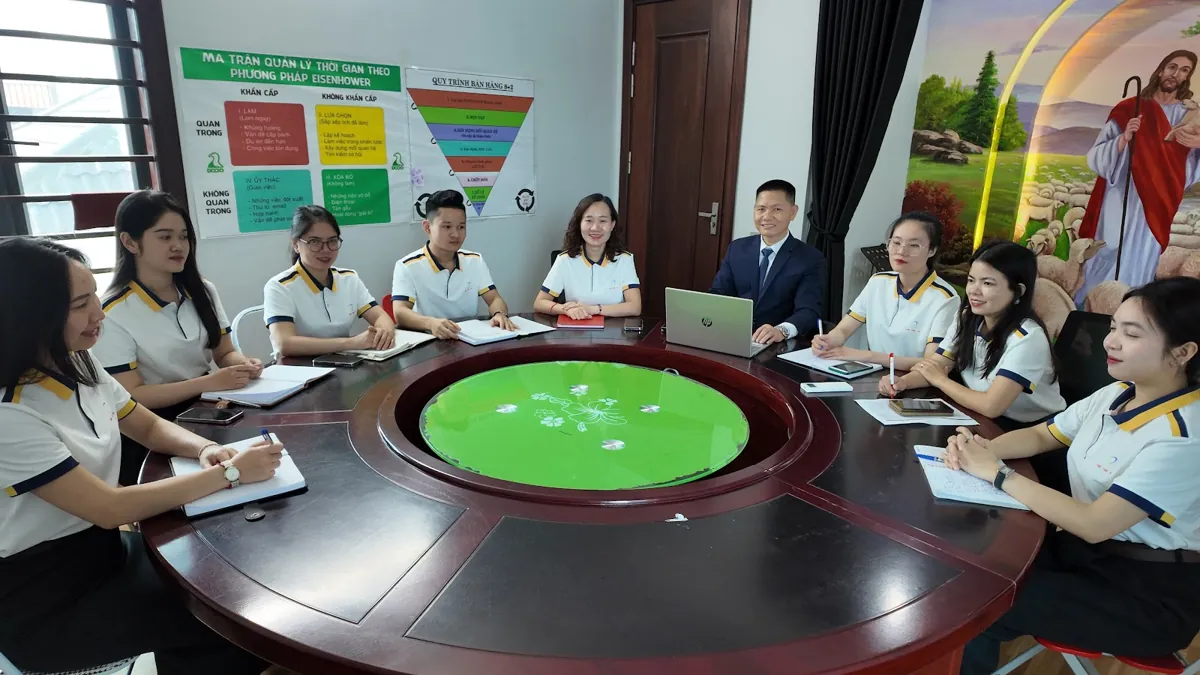 Nhân viên và anh Nguyễn Quốc Huy họp quanh bàn tròn lớn tại Tâm - Tầm - Tài – Chi phí thành lập công ty cổ phần