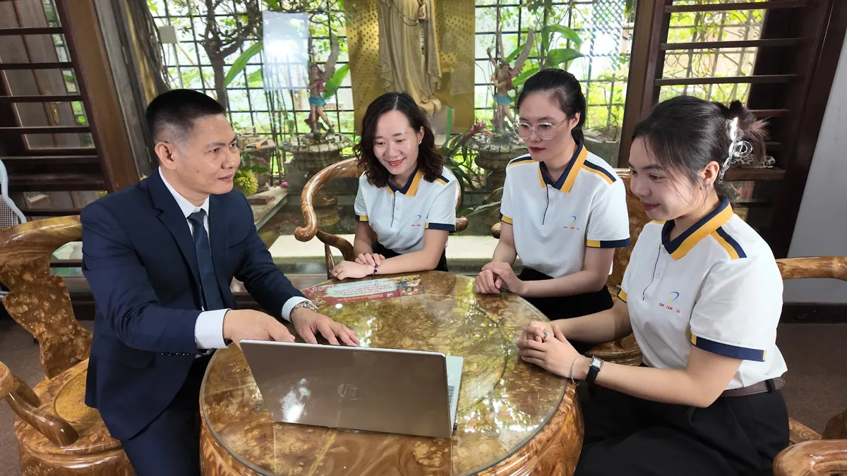 Anh Nguyễn Quốc Huy giải thích trên laptop, chị Thảo và nhân viên lắng nghe tại Tâm - Tầm - Tài – Chi phí thành lập công ty tnhh 1 thành viên
