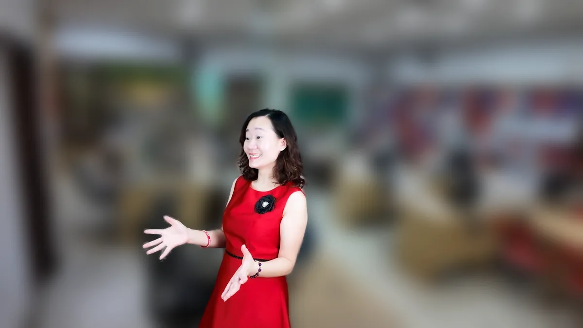 Chị Thảo Nguyễn váy đỏ đưa tay như giới thiệu, mỉm cười tại văn phòng Tâm - Tầm - Tài – chia sẻ về chi phí thành lập công ty tnhh 1 thành viên