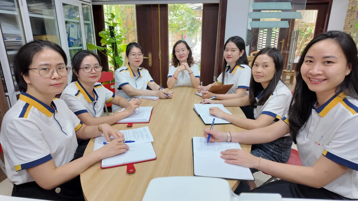 Nhóm nhân viên nữ họp quanh bàn dài, mỉm cười nhìn ống kính tại Tâm - Tầm - Tài – Có nên thành lập công ty không
