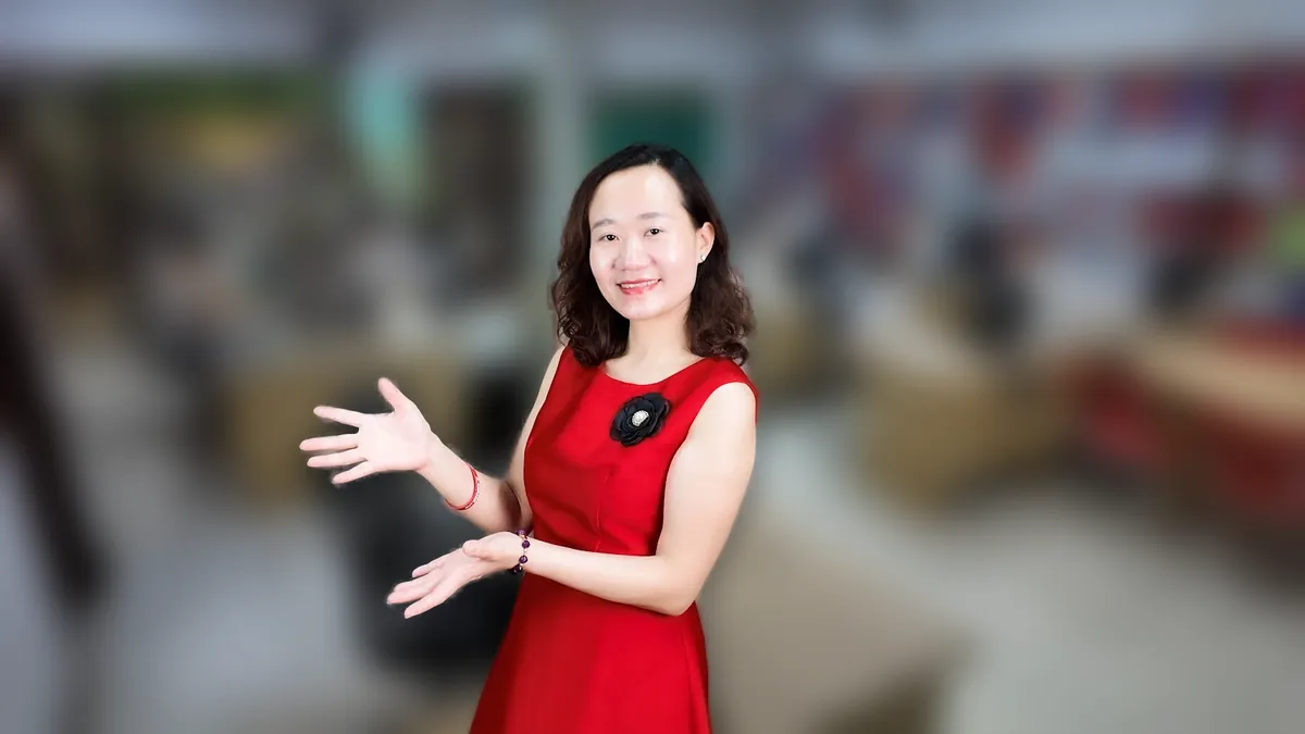Chị Thảo Nguyễn váy đỏ đưa tay như giới thiệu, mỉm cười tại văn phòng Tâm - Tầm - Tài – chia sẻ về có nên thành lập công ty không