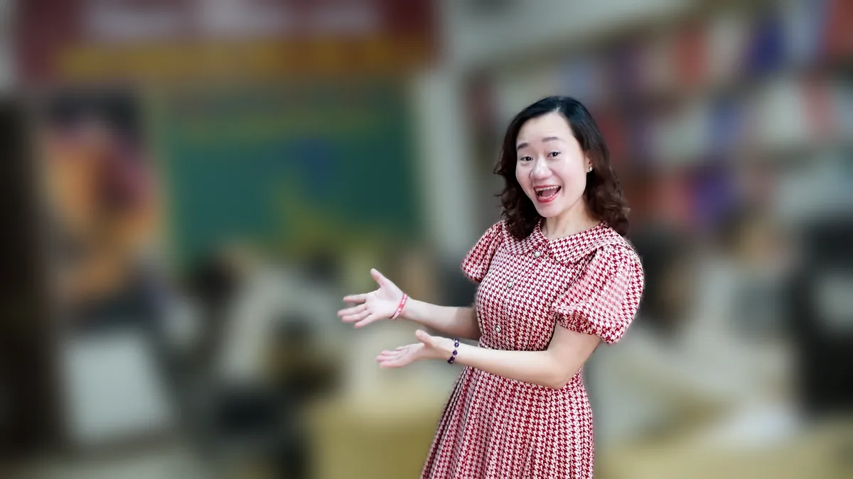 Chị Thảo Nguyễn váy caro khoanh tay đứng nghiêng, mỉm cười tại văn phòng Tâm - Tầm - Tài – chia sẻ về đăng ký hộ kinh doanh ở đâu