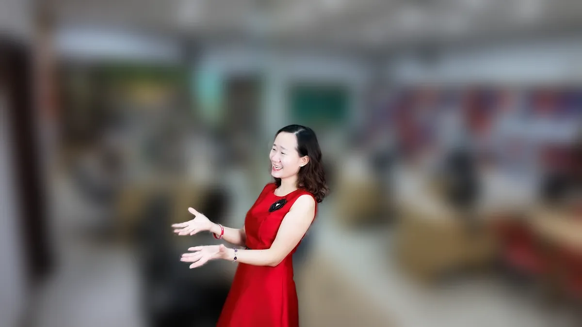 Chị Thảo Nguyễn váy đỏ cầm điện thoại, đứng mỉm cười tại văn phòng Tâm - Tầm - Tài – chia sẻ về đăng ký kinh doanh ở đâu