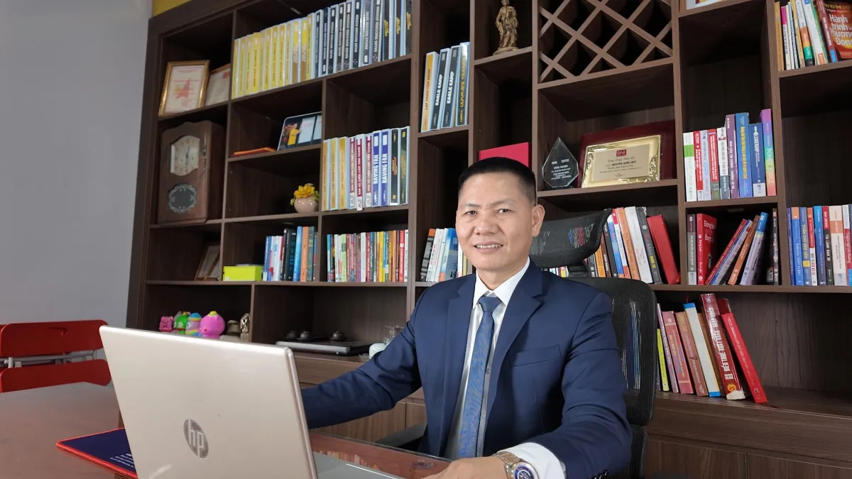 Anh Nguyễn Quốc Huy mỉm cười bên laptop trong phòng làm việc tại Tâm - Tầm - Tài – Đăng ký kinh doanh online dịch vụ công