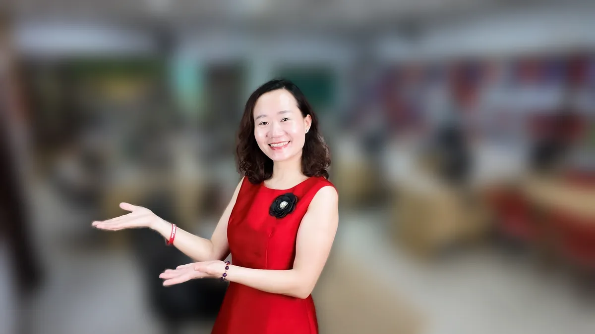 Chị Thảo Nguyễn váy đỏ đưa tay như giới thiệu, mỉm cười tại văn phòng Tâm - Tầm - Tài – chia sẻ về đăng ký kinh doanh online dịch vụ công