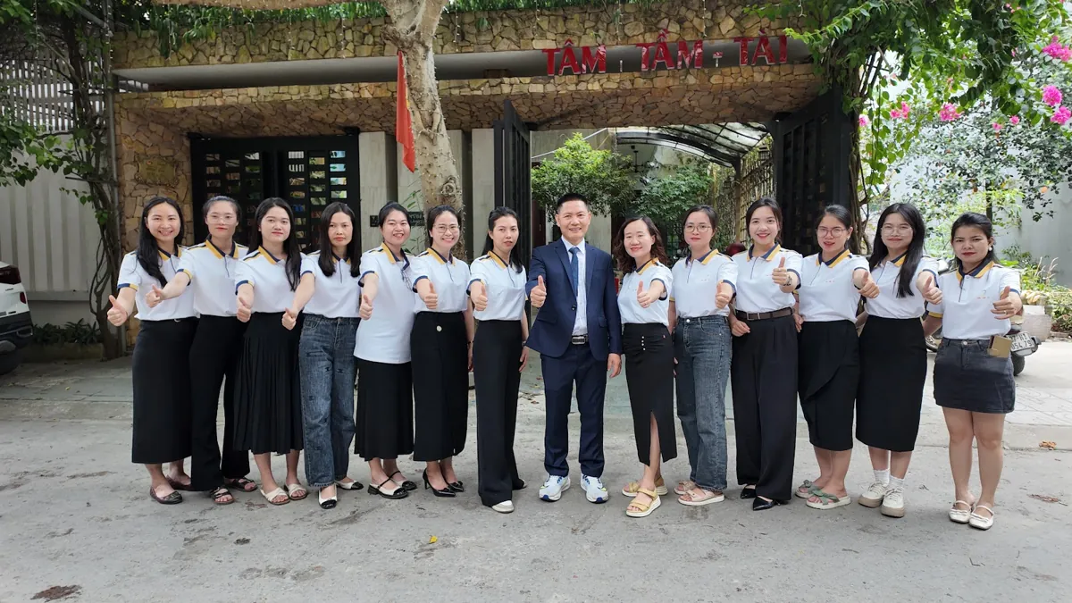 Ảnh tập thể đội ngũ trước cổng có biển Tâm - Tầm - Tài – Đăng ký nhãn hiệu