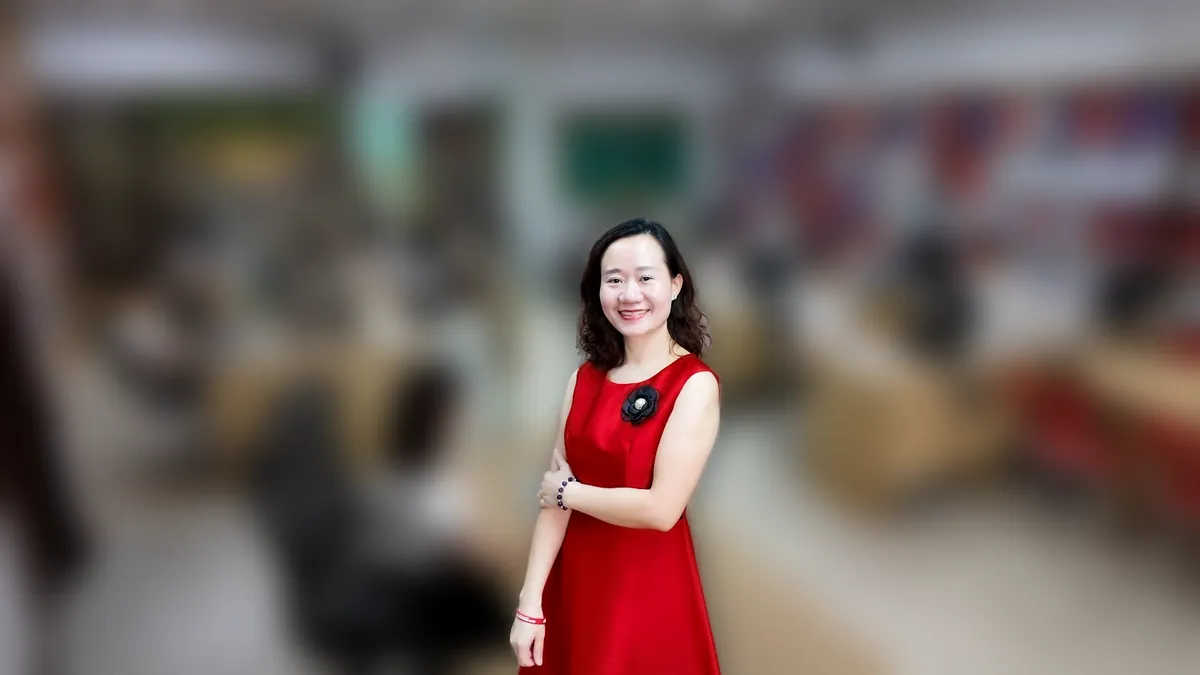 Chị Thảo Nguyễn váy đỏ đứng thẳng mỉm cười tại văn phòng Tâm - Tầm - Tài – chia sẻ về đăng ký nhãn hiệu