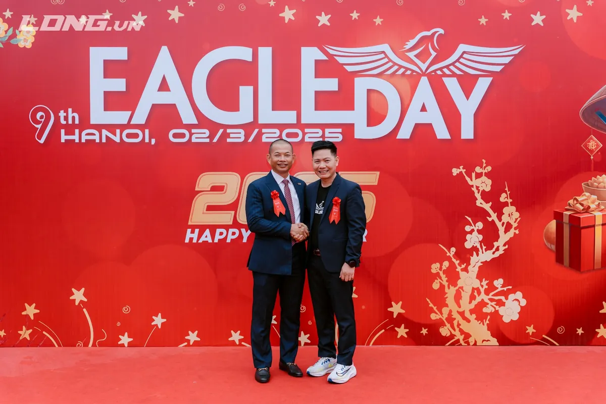 Anh Nguyễn Quốc Huy bắt tay thầy Long trước phông Eagle Day 2025 – Khách hàng tâm tầm tài