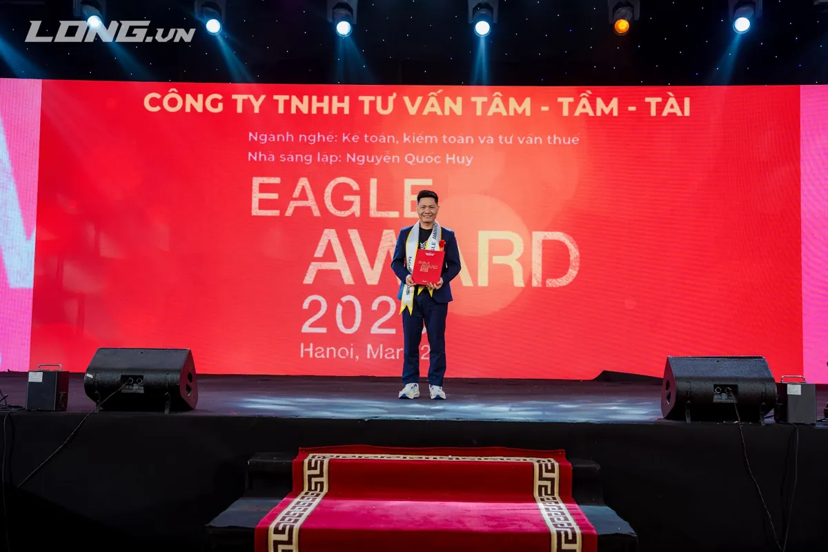 Anh Nguyễn Quốc Huy nhận giải trên sân khấu, màn hình ghi Tâm - Tầm - Tài – Khách hàng tâm tầm tài