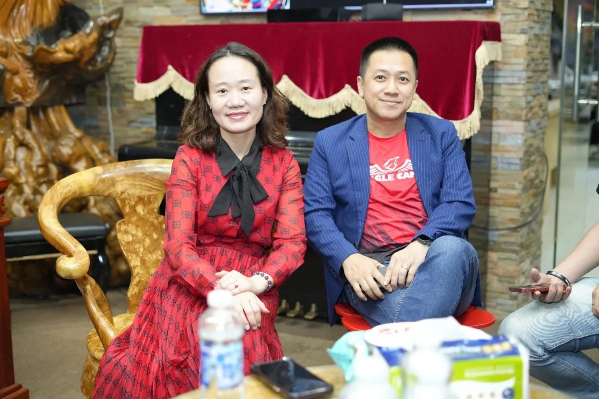 Chị Thảo Nguyễn và doanh nhân ngồi ghế gỗ tiếp khách, mỉm cười tại Tâm - Tầm - Tài – chia sẻ về khách hàng tâm tầm tài