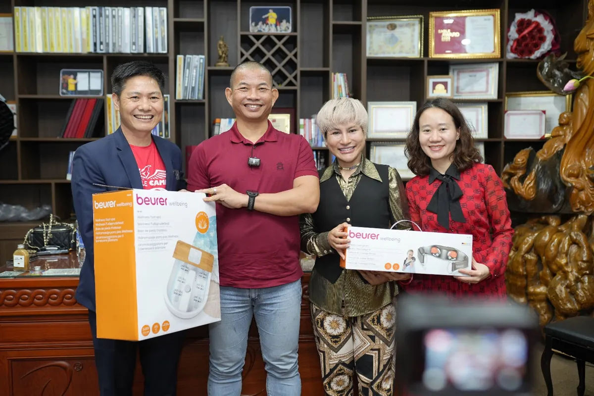 Anh Nguyễn Quốc Huy, thầy Long và hai khách nữ cầm quà trước tủ sách tại Tâm - Tầm - Tài – Kinh nghiệm thành lập công ty