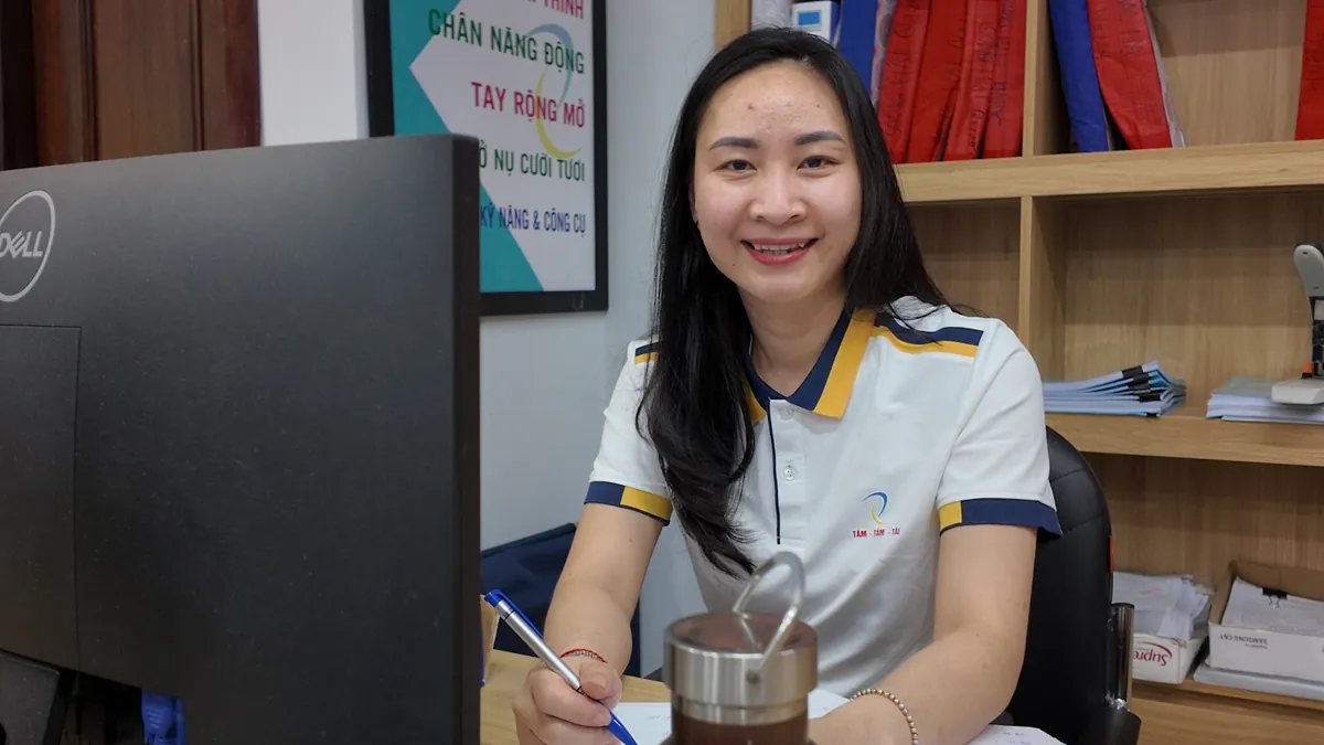 Nhân viên nữ cầm bút làm việc tại bàn, kệ hồ sơ phía sau tại Tâm - Tầm - Tài – Mở công ty cần bằng cấp gì