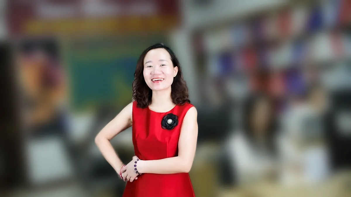Chị Thảo Nguyễn váy đỏ chống hông, mỉm cười nhìn thẳng tại văn phòng Tâm - Tầm - Tài – chia sẻ về mở công ty cần giấy tờ gì
