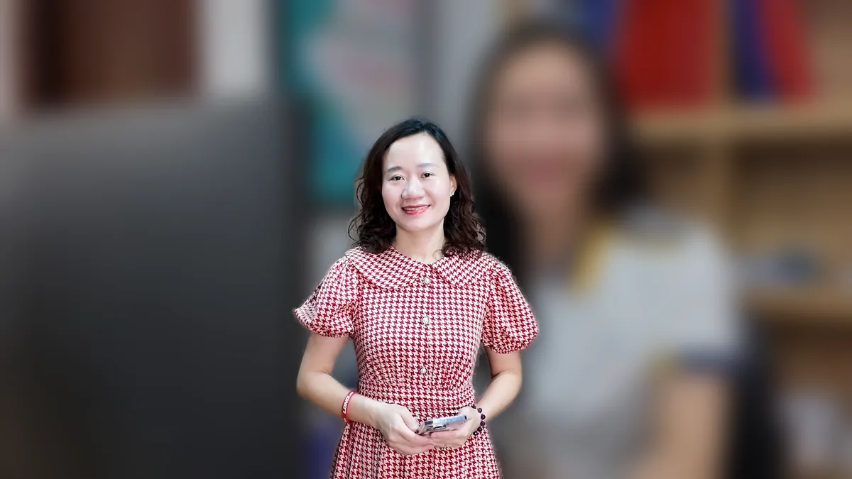 Chị Thảo Nguyễn mặc váy caro đỏ đứng cười tại văn phòng Tâm - Tầm - Tài – chia sẻ về thay đổi đăng ký kinh doanh