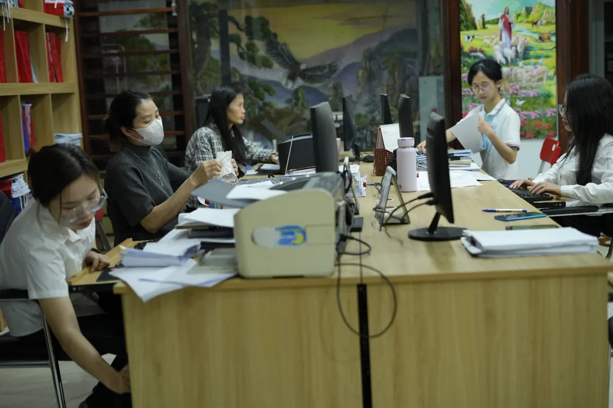Nhân viên ngồi bàn dài xử lý giấy tờ, máy tính tại Tâm - Tầm - Tài – Thủ tục giải thể công ty