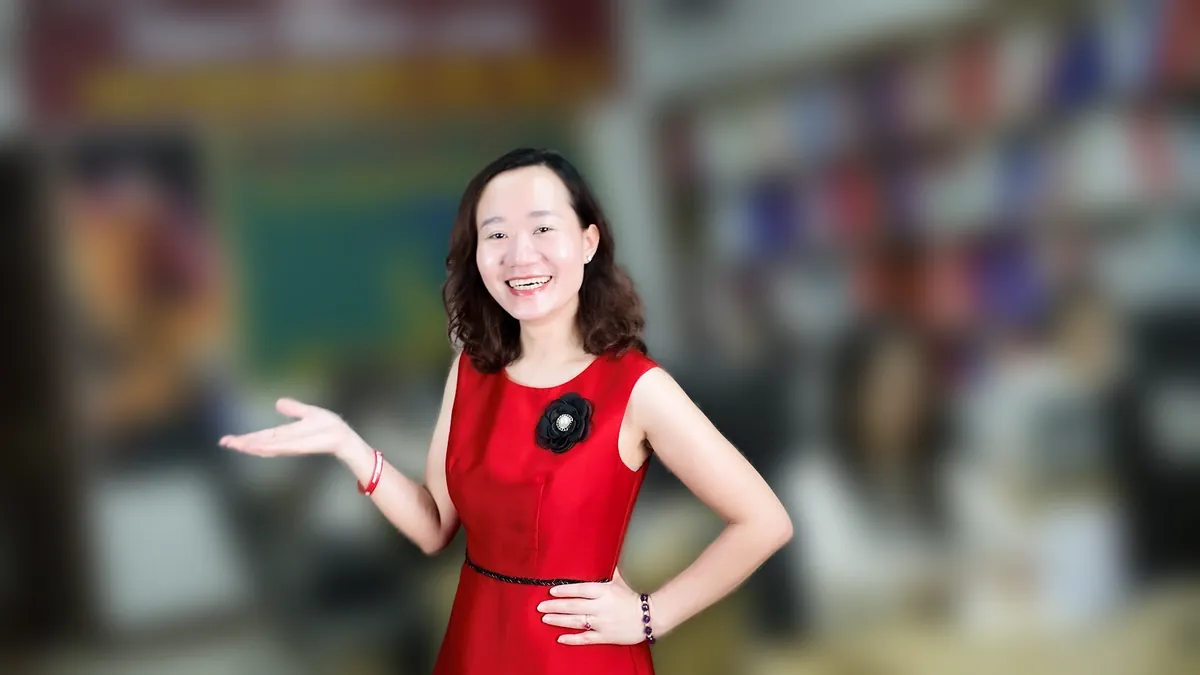 Chị Thảo Nguyễn váy đỏ chống hông, mỉm cười nhìn thẳng tại văn phòng Tâm - Tầm - Tài – chia sẻ về thủ tục giải thể công ty