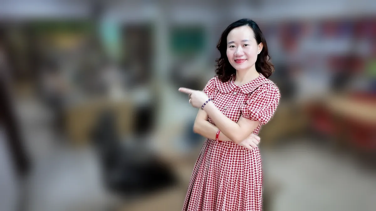 Chị Thảo Nguyễn váy caro khoanh tay, mỉm cười nhìn nghiêng tại văn phòng Tâm - Tầm - Tài – chia sẻ về thủ tục mở trung tâm ngoại ngữ