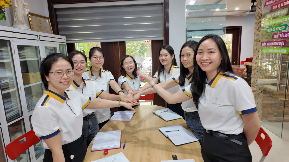 Đội ngũ nhân viên chồng tay đoàn kết quanh bàn họp tại Tâm - Tầm - Tài – Tra cứu nhãn hiệu trước khi đăng ký