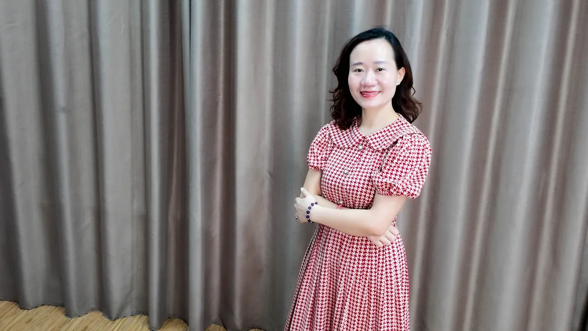 Thảo váy caro khoanh tay, mỉm cười nhìn nghiêng