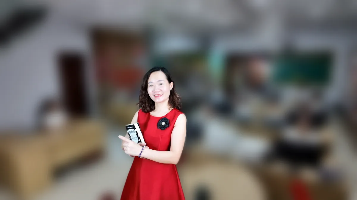Chị Thảo Nguyễn váy đỏ đứng cầm cuốn sách tại văn phòng Tâm - Tầm - Tài – chia sẻ về câu hỏi phỏng vấn kế toán thuế