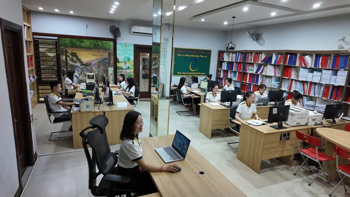 Toàn cảnh văn phòng Tâm - Tầm - Tài, nhân viên ngồi laptop ở tiền cảnh – Đăng ký hộ kinh doanh online 2026