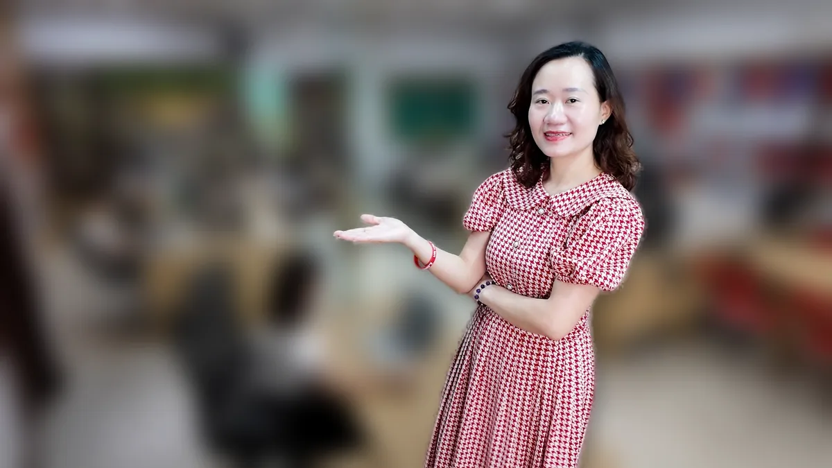Chị Thảo Nguyễn váy caro đứng nghiêng, tay đặt cằm mỉm cười tại văn phòng Tâm - Tầm - Tài – chia sẻ về đăng ký hoá đơn điện tử hộ kinh doanh