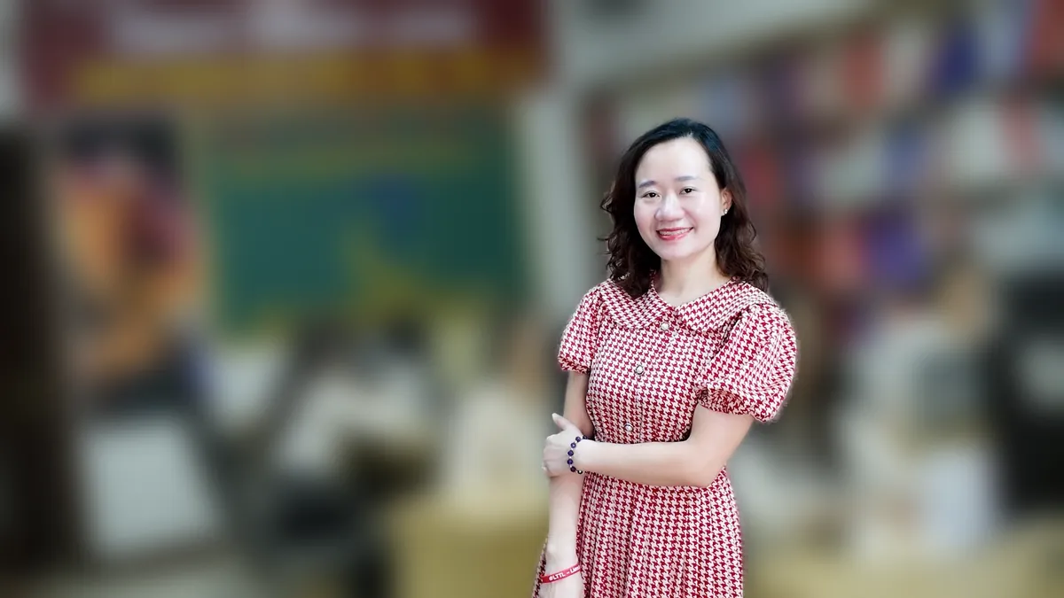 Chị Thảo Nguyễn váy caro khoanh tay đứng nghiêng, mỉm cười tại văn phòng Tâm - Tầm - Tài – chia sẻ về dịch vụ kế toán thuế là gì