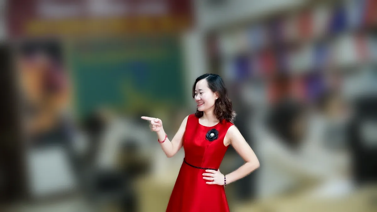 Chị Thảo Nguyễn váy đỏ đứng thẳng mỉm cười tại văn phòng Tâm - Tầm - Tài – chia sẻ về đóng hộ kinh doanh cần gì