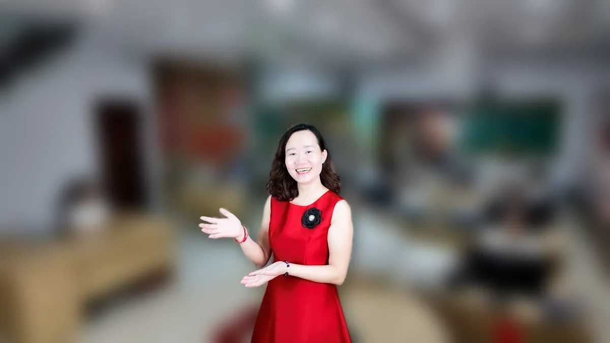 Chị Thảo Nguyễn váy caro đỏ đưa hai tay như giới thiệu, mỉm cười tại văn phòng Tâm - Tầm - Tài – chia sẻ về luật hộ kinh doanh 2026