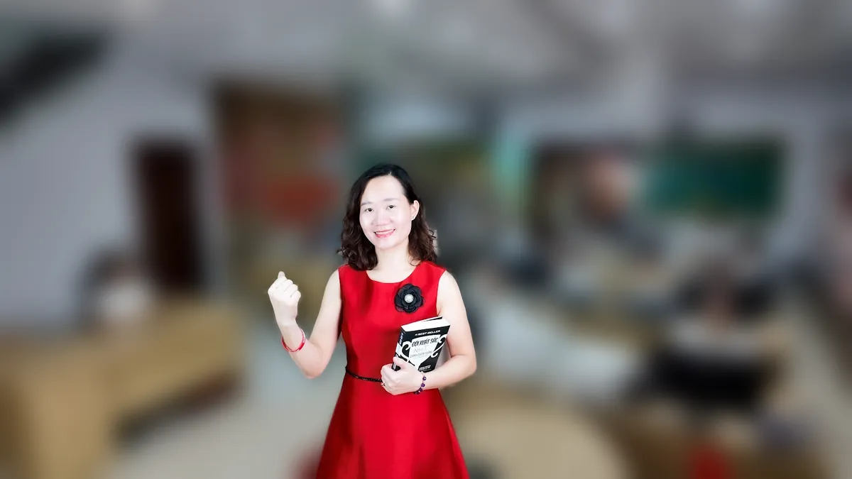 Chị Thảo Nguyễn váy caro đỏ đưa hai tay như giới thiệu, mỉm cười tại văn phòng Tâm - Tầm - Tài – chia sẻ về mẫu đăng ký hộ kinh doanh 2026