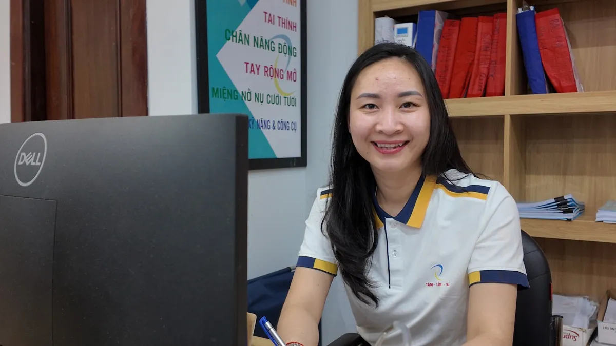 Nhân viên nữ ngồi bàn máy tính mỉm cười nhìn ống kính tại Tâm - Tầm - Tài – Sau khi thành lập công ty cần làm gì