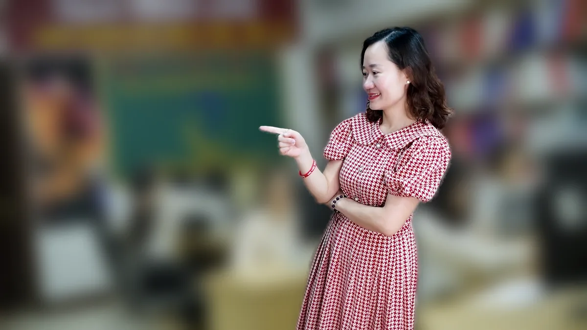 Chị Thảo Nguyễn váy caro đứng nghiêng, tay đặt cằm mỉm cười tại văn phòng Tâm - Tầm - Tài – chia sẻ về thuế hộ kinh doanh 2026
