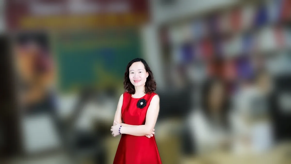 Chị Thảo Nguyễn váy đỏ đưa tay như giới thiệu, mỉm cười tại văn phòng Tâm - Tầm - Tài – chia sẻ về văn phòng đại diện có được kinh doanh không